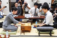 将棋棋聖戦１次予選で、初手を指す里見香奈女流王座（左）。右は藤井聡太七段＝大阪市福島区で２０１８年８月２４日午前１０時、山崎一輝撮影