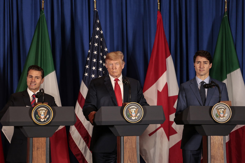 新貿易協定に調印する米加メキシコの首脳。中央がトランプ米大統領(Bloomberg)