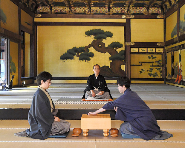 本因坊戦第2局、国宝の二条城二の丸御殿で初手を打つ本因坊文裕(手前右)。左は挑戦者の山下敬吾九段=京都市中京区で5月23日、川平愛撮影