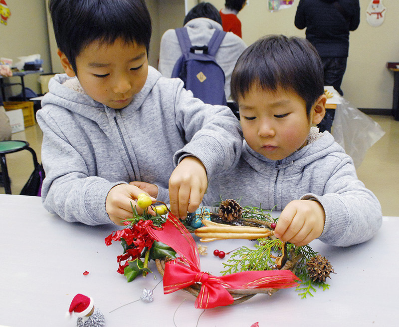 クリスマスリース作りに挑戦する子供たち=兵庫県伊丹市桑津3の伊丹市立こども文化科学館で、近藤諭撮影