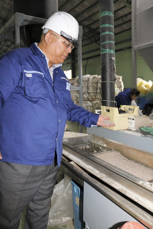 再生原料のペレットを手にする亜星商事の孫自強社長=茨城県笠間市の工場で2018年11月8日、田口雅士撮影