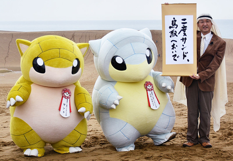 来県を呼び掛けるポケモンのキャラクター、サンド(左の2体)と平井伸治鳥取県知事=鳥取市の鳥取砂丘で、園部仁史撮影