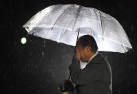 阪神大震災から２３年。甥の名前が刻まれた慰霊碑の前で顔を覆う男性＝兵庫県西宮市で２０１８年１月１７日午前５時６分、久保玲撮影