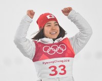 【平昌五輪】スキージャンプ女子ノーマルヒル３位となりフラワーセレモニーで笑顔で表彰台にあがる高梨沙羅＝アルペンシア・ジャンプセンターで２０１８年２月１２日、宮間俊樹撮影