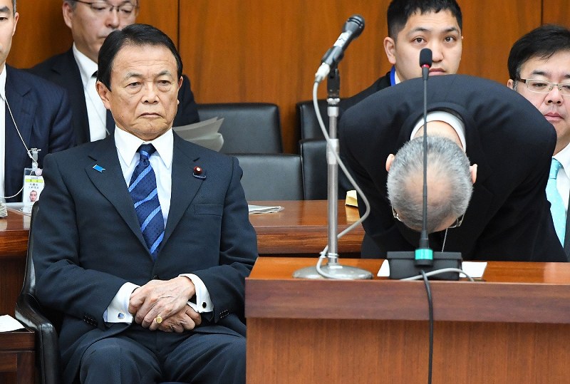 衆院財務金融委員会で学校法人「森友学園」への国有地売却に関する決裁文書の改ざん問題について陳謝し頭を下げる財務省の太田充理財局長（右）を見つめる麻生太郎財務相（左）＝国会内で２０１８年３月１６日午前９時３分、川田雅浩撮影
