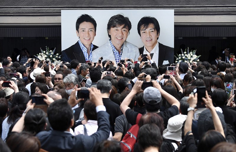 西城秀樹さんの葬儀が終わり、多くのファンが撮影する会場の入り口に飾られた西城秀樹さん（中央）、野口五郎さん（右）、郷ひろみさんの３人の写真＝東京都港区の青山葬儀所で２０１８年５月２６日午後１時９分、竹内紀臣撮影