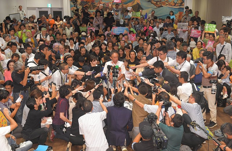 当選を確実にし、記者の質問に答える玉城デニー氏（中央）＝那覇市で２０１８年９月３０日午後９時４４分、徳野仁子撮影