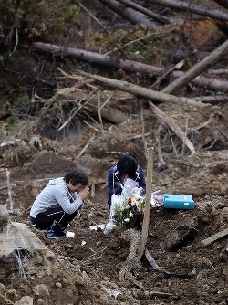地震発生から１カ月。地震による土砂崩れで３人が亡くなった場所で手を合わせる女性＝北海道厚真町で２０１８年１０月６日午後２時３８分、貝塚太一撮影