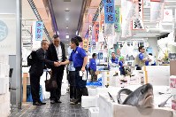 開場した豊洲市場の水産仲卸売場で、顧客の男性と笑顔で握手を交わす「山治」の山崎康弘社長（右）＝東京都江東区で２０１８年１０月１１日午前７時５１分、竹内紀臣撮影