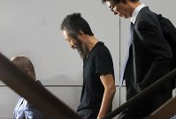 航空機から降り、階段で笑顔を見せる安田純平さん（中央）＝成田国際空港で２０１８年１０月２５日午後６時３６分、梅村直承撮影