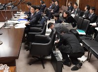 参院法務委員会で外国人労働者の受け入れを拡大する入管法改正案について山下貴司法相（左手前）の答弁の準備をする事務方たち（中央手前）＝国会内で２０１８年１２月４日午前１１時４１分、川田雅浩撮影