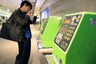 ソフトバンクの通信障害が起き仕事先にＪＲ東京駅近くの公衆電話から電話する男性＝東京都千代田区で２０１８年１２月６日午後６時３３分、梅村直承撮影