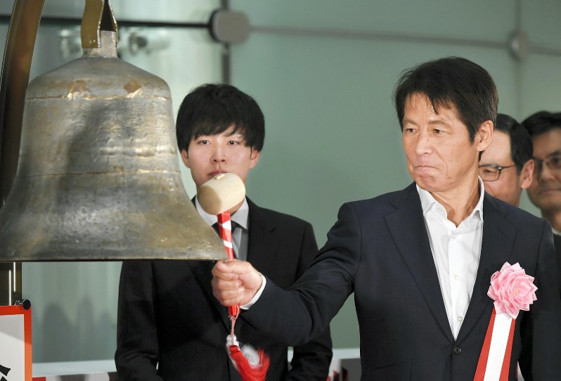 東京証券取引所の大納会で鐘を打つサッカー日本代表前監督の西野朗さん(右)=東京都中央区で2018年12月28日午後3時14分、宮間俊樹撮影