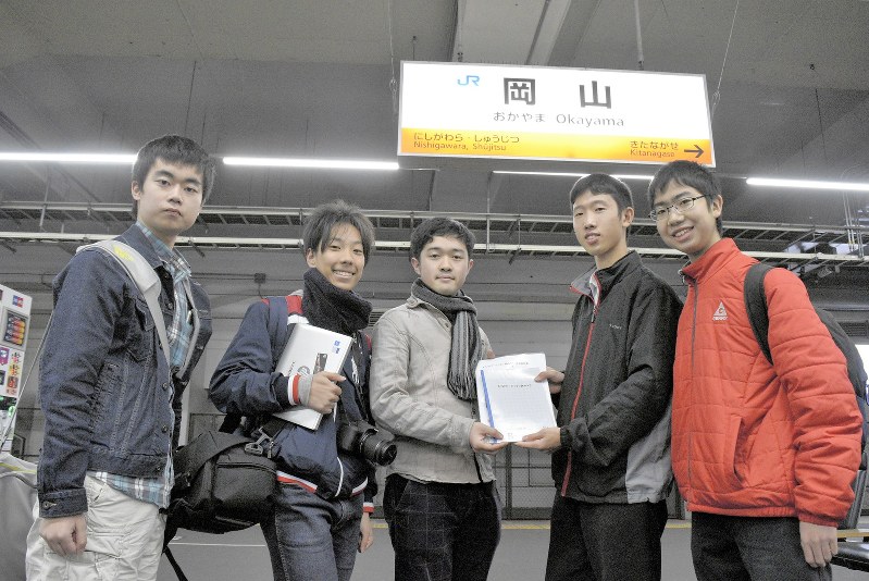 中央の男性が持ってきたノートを、高校生の小椋将史さん(右から2人目)らが受け取り、JR岩国駅へ運ぶ=岡山市北区のJR岡山駅で2018年12月27日、林田奈々撮影