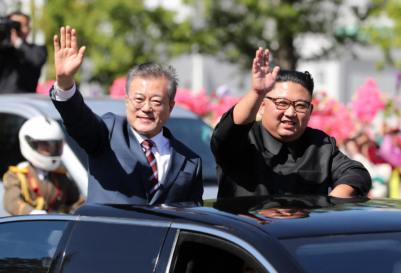 平壌に到着し、沿道で出迎える人たちに手を振る韓国の文在寅大統領(左)。右は北朝鮮の金正恩朝鮮労働党委員長=2018年9月18日、平壌写真共同取材団撮影
