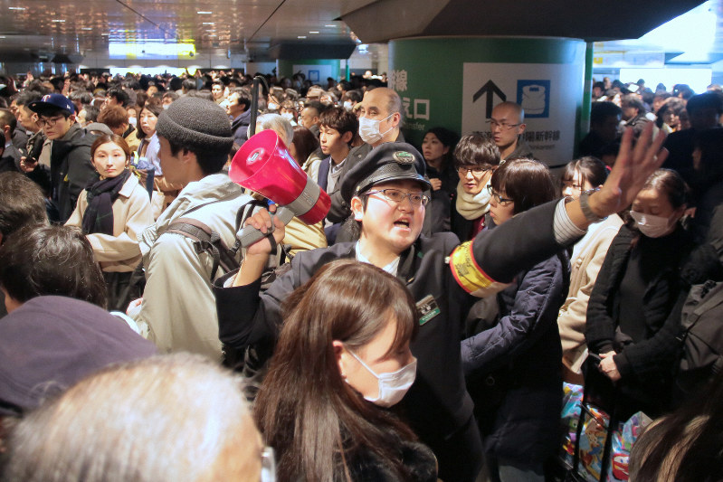 東北新幹線などで遅れが生じ、帰省客らでごった返す改札口で対応に追われる駅員=東京都千代田区のJR東京駅で2018年12月30日午後3時18分、和田大典撮影