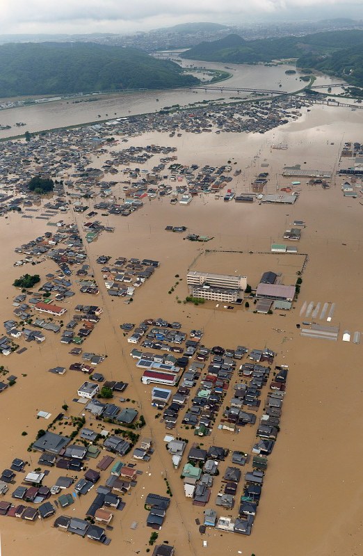 堤防が決壊し、濁流に覆われた倉敷市真備町地区。奥は高梁川=岡山県で7月7日、本社ヘリから加古信志撮影