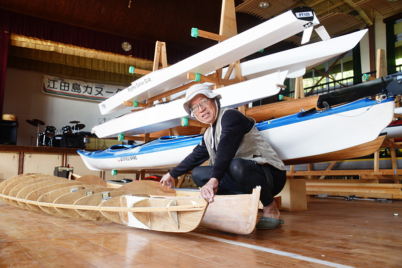 「『マリンスポーツなら江田島』と言われるよう、この町をPRしていきたい」と話す玉山義雄さん。カヌー艇も自分たちで作るなど、島の生活を満喫している=広島県江田島市沖美町畑の旧沖中学校体育館で、元田禎撮影