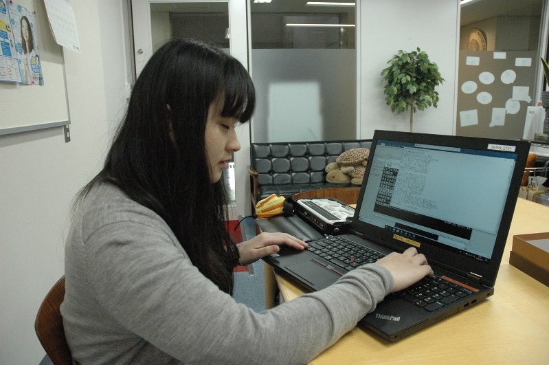 パソコンの読み上げソフトを使って論文を読む竹保さん=京都市の京都外国語大で