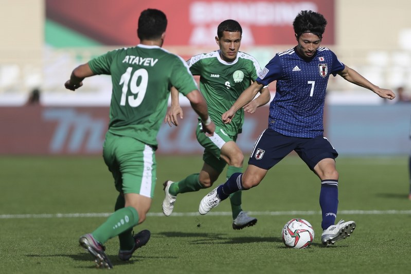アジア杯【日本・トルクメニスタン】トルクメニスタンのアタエフ、バティロフを抜く日本のMF柴崎=UAEのアブダビで2019年1月9日、AP