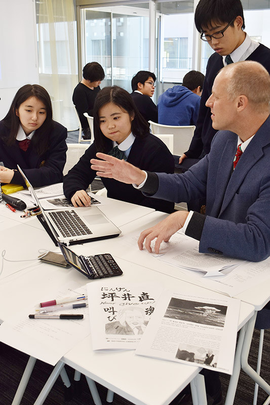 坪井直さんの半生を英訳する作業に取り組む盈進中学高校ヒューマンライツ部の生徒と京都外国語大の教員ら=京都市右京区の京都外国語大で、菅沼舞撮影