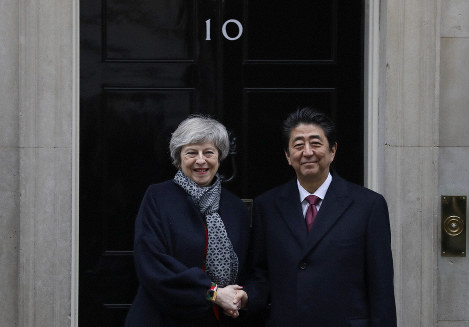 英国のメイ首相（左）と握手する安倍首相=2019年1月10日、AP