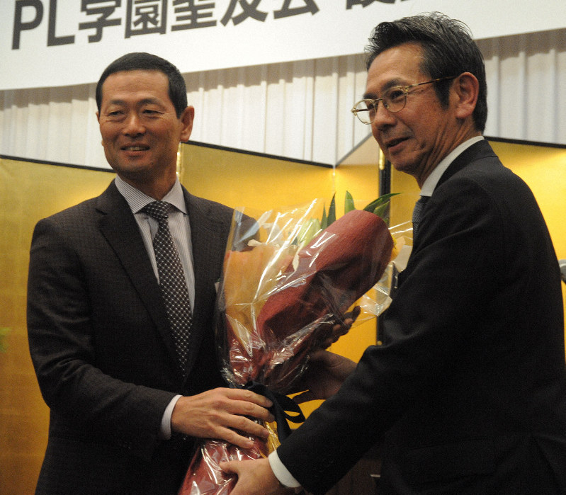 PL学園野球部OB会の総会で鶴岡秀樹前会長(右)に花束を渡す桑田真澄新会長=大阪市内のホテルで2019年1月12日、安田光高撮影