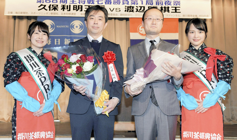 前夜祭で掛川茶PRレディから花束を受け取り記念撮影に応じる、久保利明王将(中央左)と挑戦者の渡辺明棋王(同右)=静岡県掛川市の掛川グランドホテルで2019年1月12日、小林努撮影