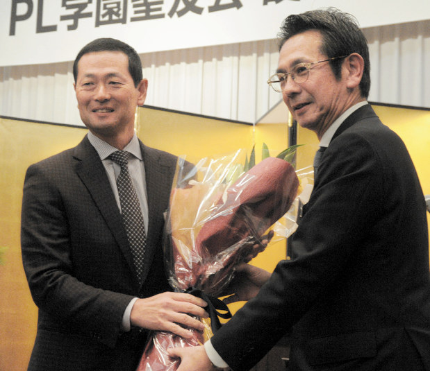 PL学園野球部OB会の総会で鶴岡前会長(右)に花束を渡す桑田新会長=大阪市内のホテルで2019年1月12日、安田光高撮影