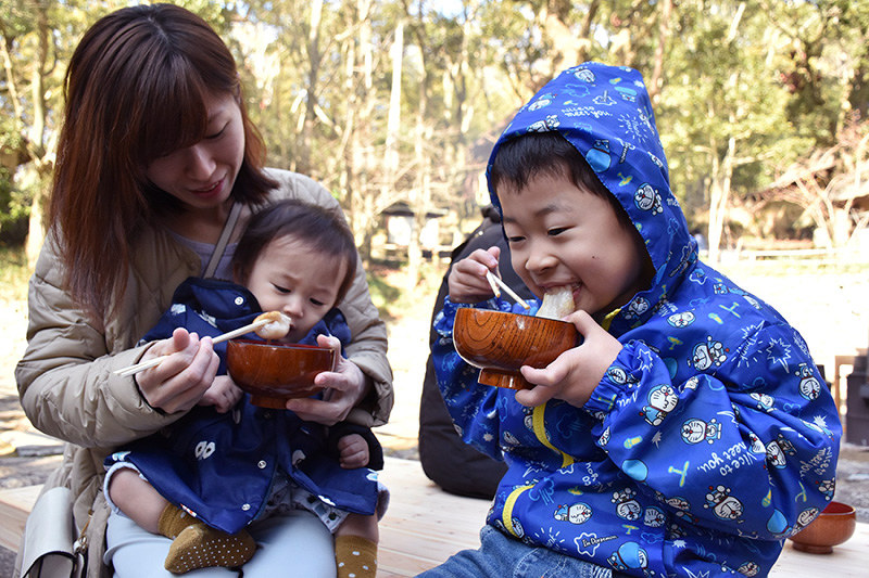 振る舞われたぜんざいを食べる親子=高松市屋島中町の四国村で、小川和久撮影