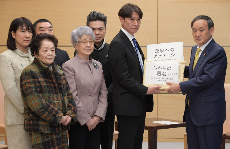 北朝鮮に拉致された横田めぐみさんとの再会を誓う同級生の会から署名簿などを受け取る菅義偉官房長官(右端)。前列左から2人目はめぐみさんの母早紀江さん=首相官邸で2019年1月15日午後2時16分、川田雅浩撮影