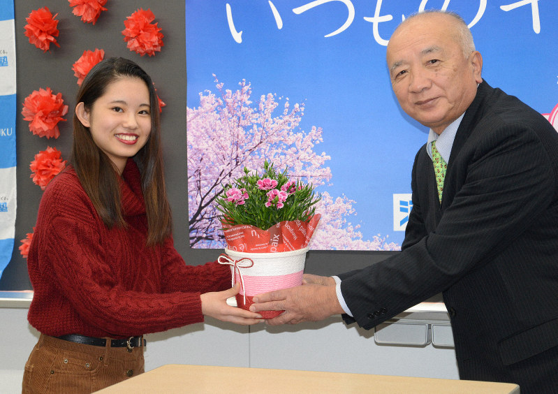 応援花のカーネーションを受け取る受験生(左)=福岡市中央区の河合塾福岡校で2019年1月15日午後1時6分、山下俊輔撮影