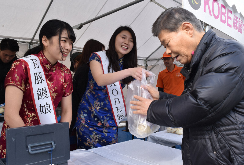 出来立ての豚まんを来場者に手渡す豚饅娘=熊本市中央区で2019年1月17日午後12時31分、城島勇人撮影