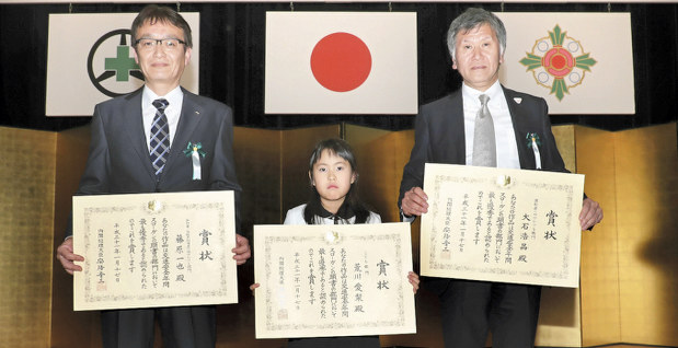 2019年使用交通安全年間スローガン表彰式で内閣総理大臣賞を受賞した(左から)兵庫県加古川市の会社員、藤原一也さん、栃木県小山市立豊田北小3年、荒川愛梨さん、大阪府高槻市の会社員、大石浩晶さん=東京都文京区春日の文京シビックホールで2019年1月17日、松田嘉徳撮影