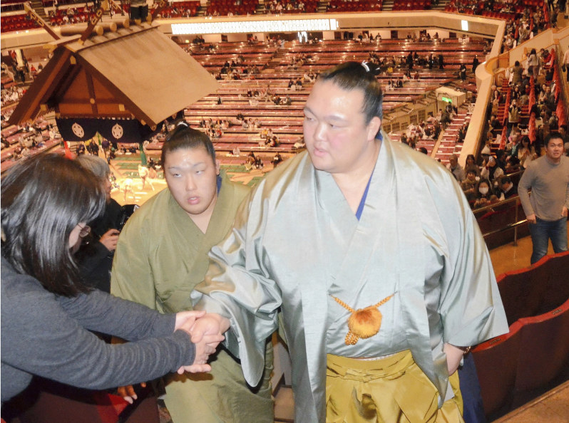 両国国技館の2階席でファンに握手で応じる元横綱・稀勢の里の荒磯親方=東京都墨田区の両国国技館で2019年1月17日、真下信幸撮影