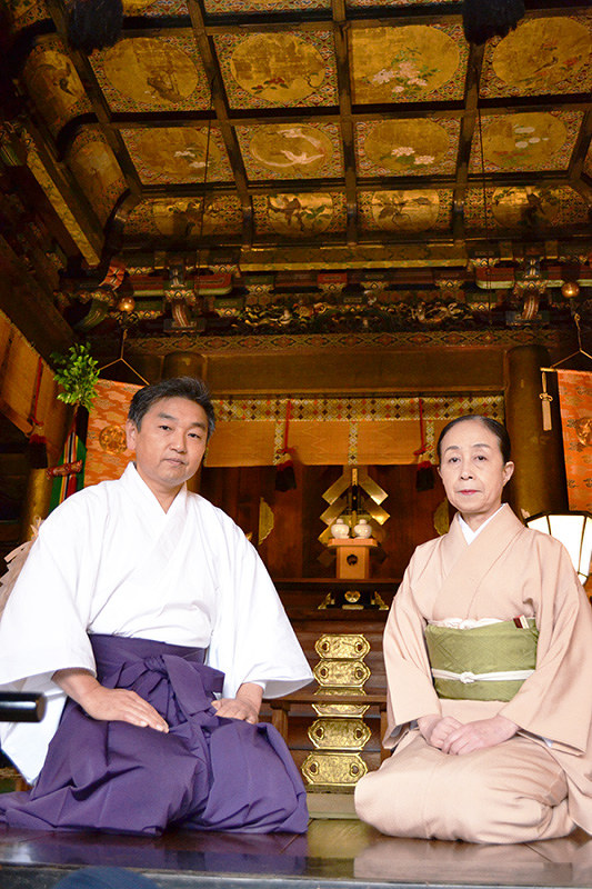 極彩色の天井画が残る拝殿に座る児玉健治宮司と市川桜香さん=名古屋市中区の名古屋東照宮で、山田泰生撮影