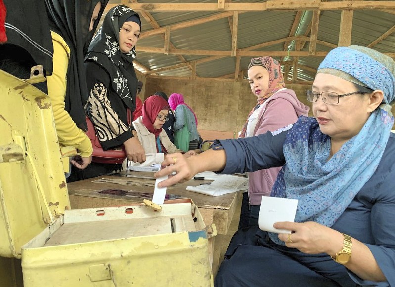 イスラム自治政府に参加するかを問う住民投票で投票するイスラム教徒の女性=フィリピン南部ミンダナオ島南ラナオ州・マラウイで21日、AP