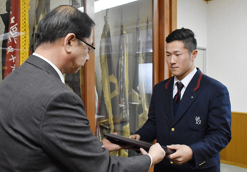 和歌山県高野連の花本明会長(左)から表彰盾を受け取る智弁和歌山高の文元洸成さん=和歌山市砂山南3の県立和歌山商高で、砂押健太撮影