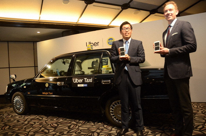 タクシー配車サービスをPRするウーバー日本法人のトム・ホワイト氏(右)と未来都の笹井大義専務=大阪市で2019年1月23日、釣田祐喜撮影