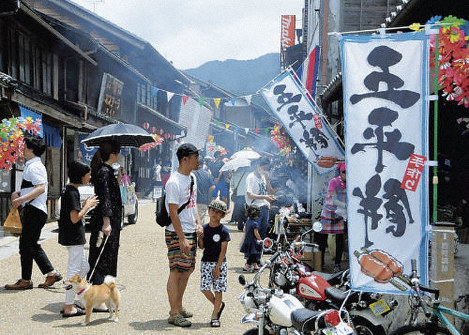人気の五平餅を求めるため店先に並ぶ観光客ら=岐阜県恵那市岩村町の城下町で、2018年6月17日、立松勝撮影