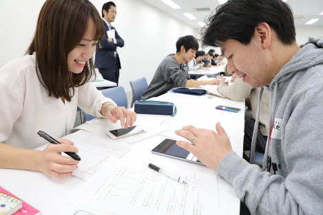アプリの説明をする芝野莉奈さん（左端）と名取知晃さん（左から3人目）と、様子を見守る高野倉雅人さん（同2人目）