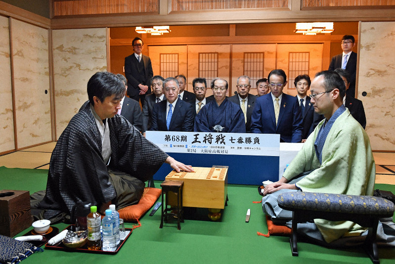 第68期王将戦第2局で初手を指す久保利明王将(左)。右は挑戦者の渡辺明棋王=大阪府高槻市の山水館で2019年1月26日午前9時、小松雄介撮影