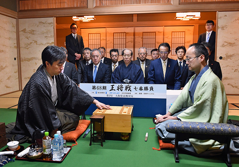 第68期王将戦第2局で初手を指す久保利明王将(左)。右は挑戦者の渡辺明棋王=大阪府高槻市の山水館で2019年1月26日午前9時、小松雄介撮影