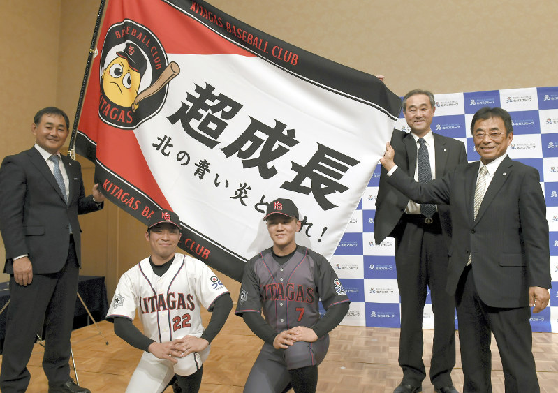 2018年4月の創部式で、新品のユニホームに身を包んだ選手たちと並ぶ北海道ガスの大槻博社長(右端)と硬式野球部の小島啓民監督(左端)=竹内幹撮影