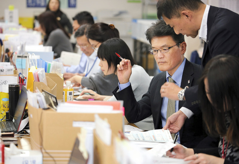 保険金支払い前に書類を最終確認する三宅信一郎さん(右から3人目)=大阪市中央区で2019年1月24日、梅田麻衣子撮影