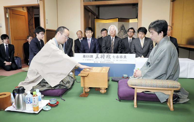 王将戦七番勝負第3局で初手を指す渡辺明棋王(左)。右は久保利明王将=栃木県大田原市のホテル花月で2019年2月6日