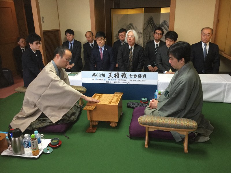 王将戦七番勝負第3局で、初手の2六歩を指す渡辺明棋王(手前左)。同右は久保利明王将=栃木県大田原市のホテル花月で2019年2月6日午前9時、丸山進撮影