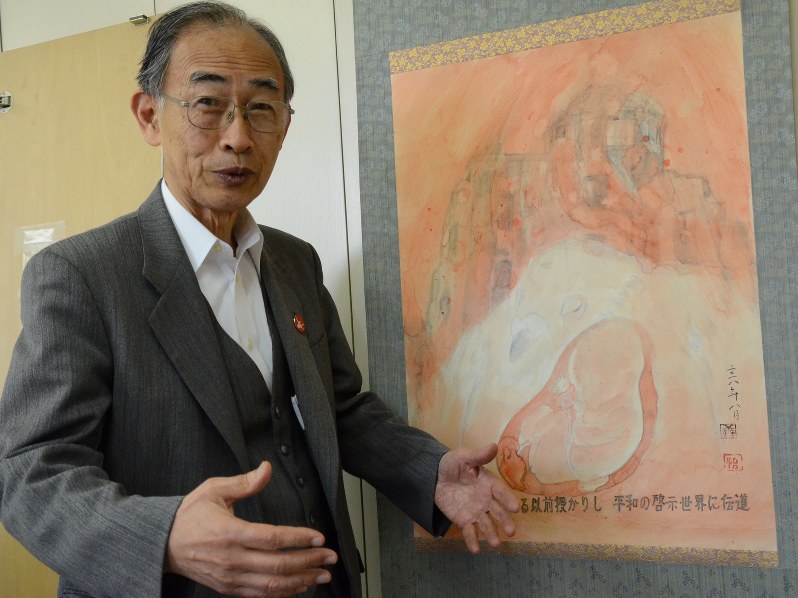 胎内被爆をテーマに描かれた絵を前に話す浜住治郎さん=東京都内で1月