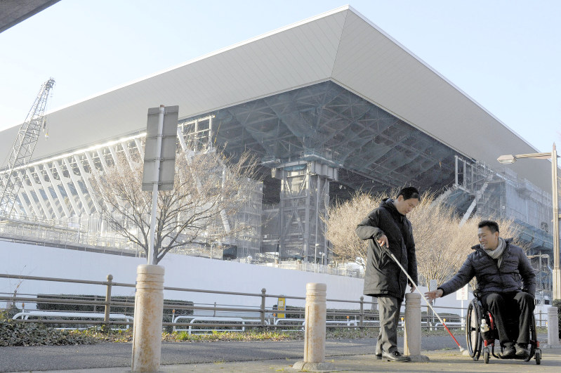 建設中のオリンピックアクアティクスセンター周辺の車止めを調べる河合純一さん(左)と三宅克己さん。選手らが利用しやすい環境整備が求められている