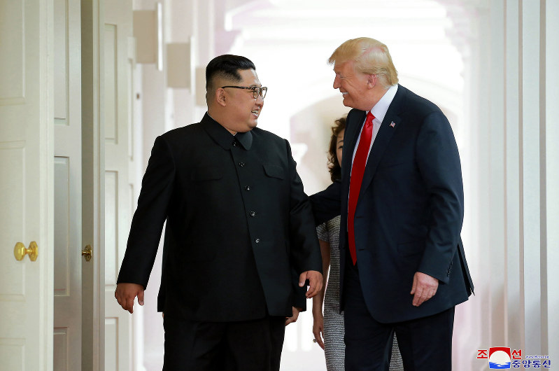 談笑しながら会談場に向かう金正恩朝鮮労働党委員長(左)とトランプ米大統領=シンガポールで2018年6月12日、朝鮮中央通信・朝鮮通信